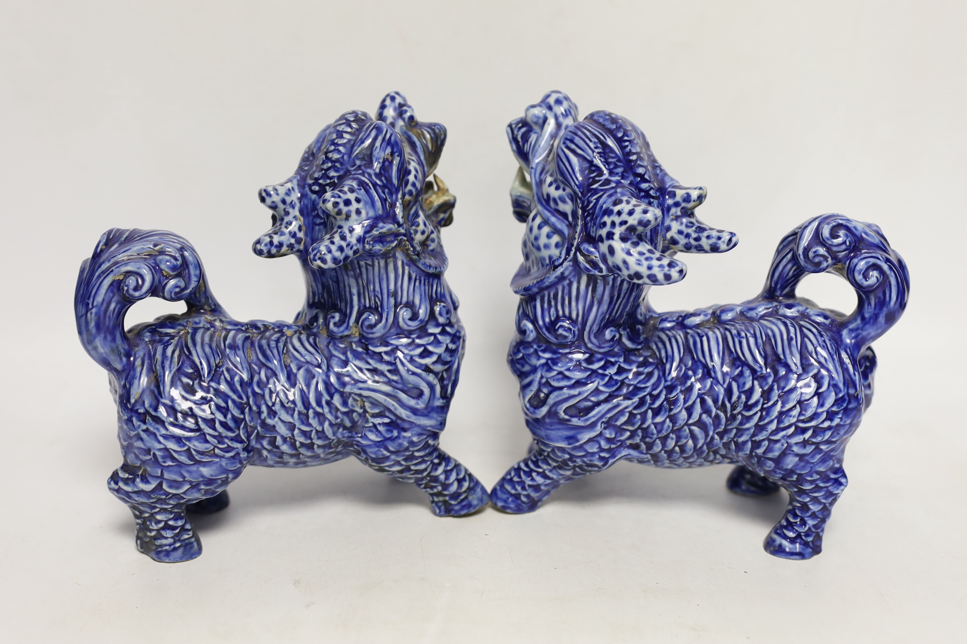 Two pairs of Chinese lion dogs; a blue and white porcelain set and a carved soapstone set, together with a carved jade lion, tallest 18cm (5)